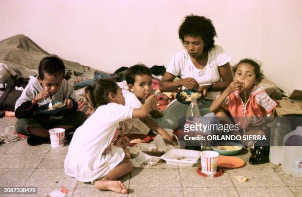 Sonia Pacheco and her four children share a meal 24 December, on Christmas Eve, in a shelter in Tegucigalpa, set up for victims of Hurricane Mitch....