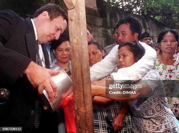 Visiting US Treasury Secretary Lawrence Summers distributes rice to residents of one of Jakarta's slum areas 20 January 2000. Summers toured the...