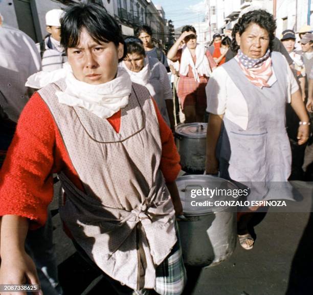 Volunteers take food to feed the demonstraters in the plaza Armas de Cochabamba, 10 April 2000. Voluntarias llevan ollas de comida para alimentar a...