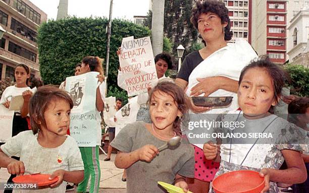 Una madre y tres de sus hijos muestran los platos vacios en demanda de alimentos al presidente Carlos Roberto Reina el 16 de Octubre durante una...