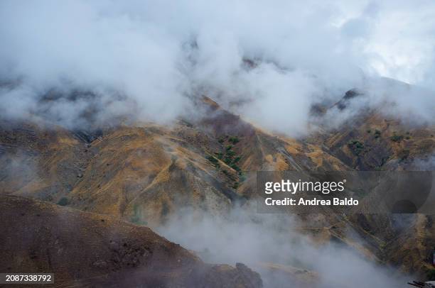 The rugged peaks of Alamut Valley are shrouded in fog in this early morning capture, with the bare, earth-toned ridges in the foreground standing...