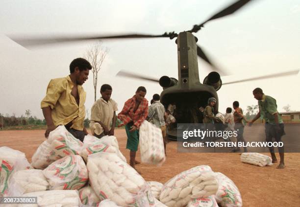 This file photo dated 04 December shows refugees from Indonesia's Irian Jaya province unloading emergency food aid from an Australian Army Chinook...