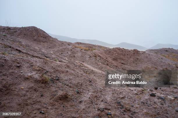 The rugged peaks of Alamut Valley are shrouded in fog in this early morning capture, with the bare, earth-toned ridges in the foreground standing...