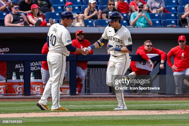 Milwaukee Brewers left fielder Christian Yelich shakes the hand of Milwaukee Brewers third base coach Jason Lane after hitting a home run during the...