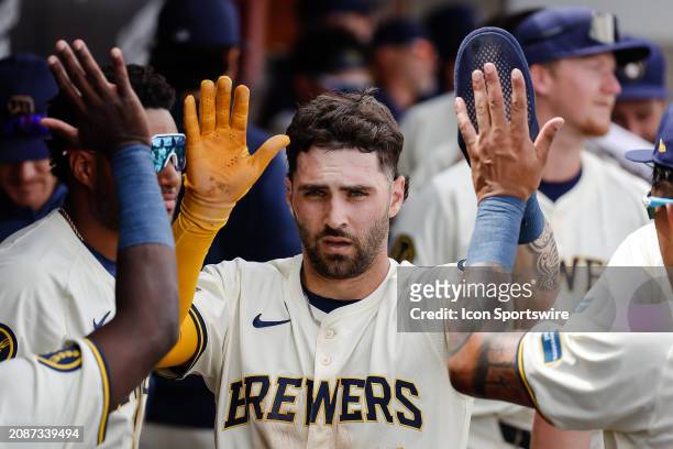 Milwaukee Brewers center fielder Garrett Mitchell hight fives teammates after scoring during the MLB spring training baseball game between the Los...