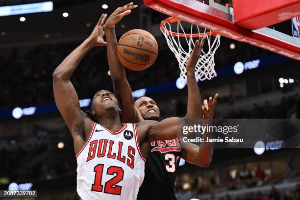 Ayo Dosunmu of the Chicago Bulls and Jabari Walker of the Portland Trail Blazers battle for a rebound in the first half on March 18, 2024 at United...