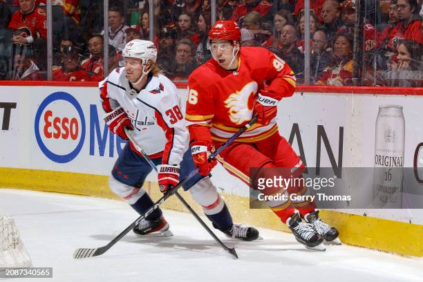 Andrei Kuzmenko of the Calgary Flames skates up ice against Rasmus Sandin of the Washington Capitals at Scotiabank Saddledome on March 18, 2024 in...