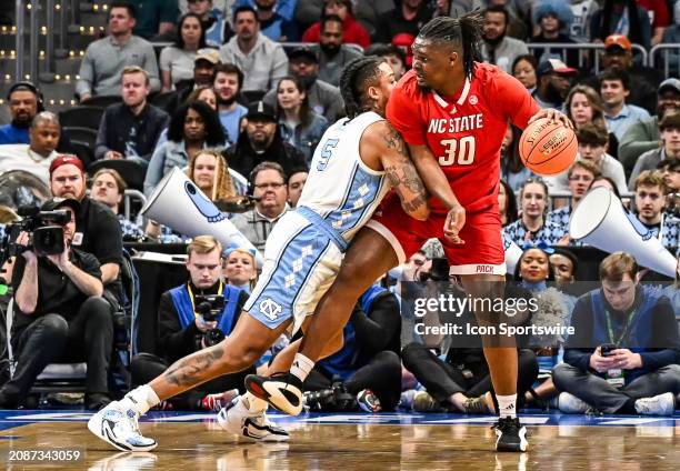 North Carolina Tar Heels forward Armando Bacot tries to defend against North Carolina State Wolfpack forward DJ Burns Jr. In the ACC Tournament...