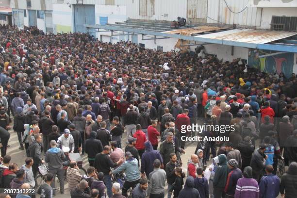 Palestinians wait in front of the United Nations Relief and Works Agency for Palestine Refugees in the Near East distribution center to receive a...