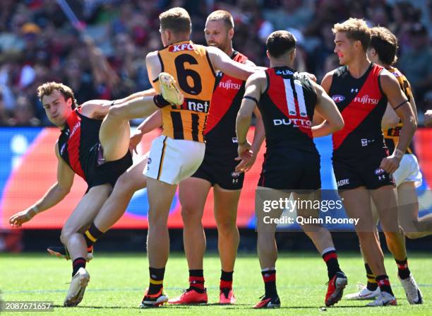 James Sicily of the Hawks gives away a free kick to Andrew McGrath of the Bombers during the round one AFL match between Essendon Bombers and...