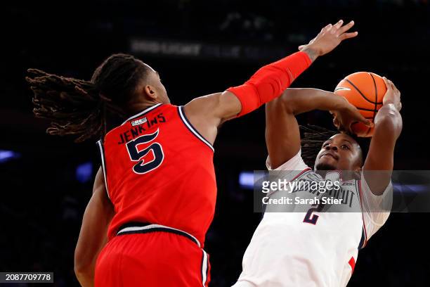 Tristen Newton of the Connecticut Huskies goes to the basket as Daniss Jenkins of the St. John's Red Storm defends in the second half during the...