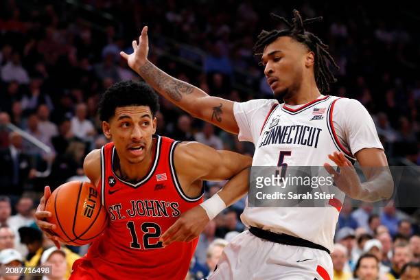 Stephon Castle of the Connecticut Huskies guards RJ Luis Jr. #12 of the St. John's Red Storm in the first half during the Semifinal round of the Big...