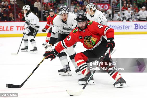 Colin Blackwell of the Chicago Blackhawks controls the puck against Andreas Englund of the Los Angeles Kings during the third period at the United...