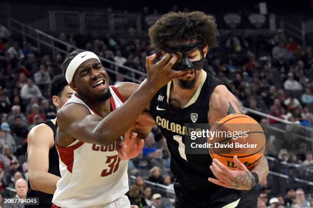 Vonne Hadley of the Colorado Buffaloes gets poke in the eye by Kymany Houinsou of the Washington State Cougars in the first half of a semifinal game...