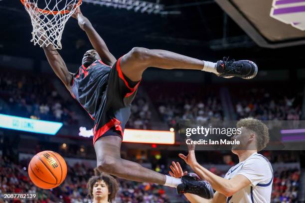 Jay Pal of the San Diego State Aztecs dunks the ball in front of Mason Falslev of the Utah State Aggies during the second half of a semifinal game of...