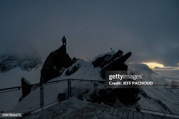 French mountaineer Charles Dubouloz stands on a ridge at sunset near the Glacier Du Geant around the Cosmiques hut, in the Mont Blanc Massif, around...