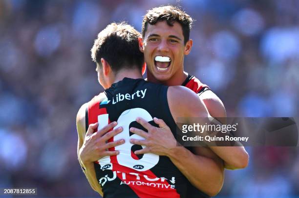 Jye Caldwell of the Bombers is congratulated by team mates after kicking a goal during the round one AFL match between Essendon Bombers and Hawthorn...