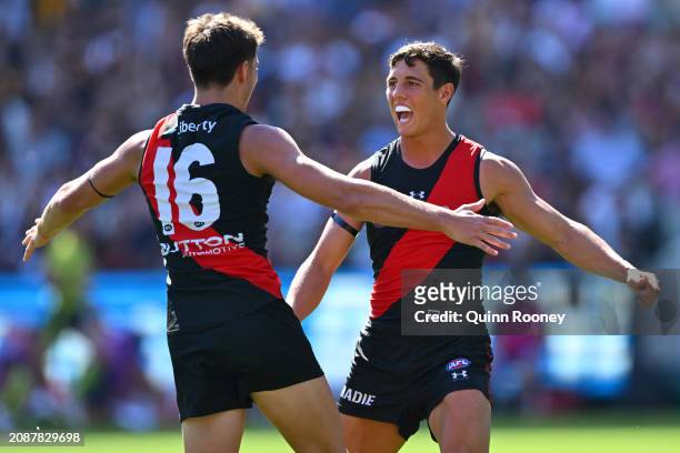 Jye Caldwell of the Bombers is congratulated by Archie Perkins after kicking a goal during the round one AFL match between Essendon Bombers and...