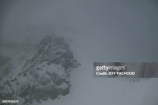Alpinists move on the Aiguille du Midi ridge, in the Mont Blanc Massif, around Chamonix, in the French Alps, on March 11, 2024.
