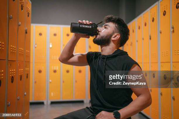 young man in locker room, at the gym. - backstage door stock pictures, royalty-free photos & images