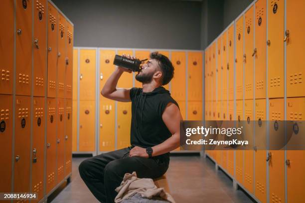young man in locker room, at the gym. - men locker room stock pictures, royalty-free photos & images