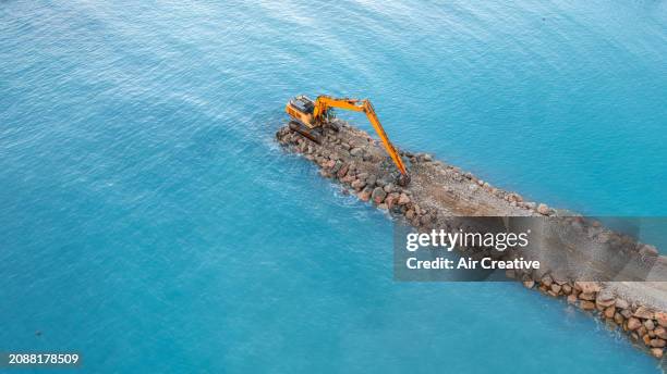 aerial view of a crawler excavator on a stone jetty projecting into the sea, alpes-maritimes, france - grävmaskin bildbanksfoton och bilder
