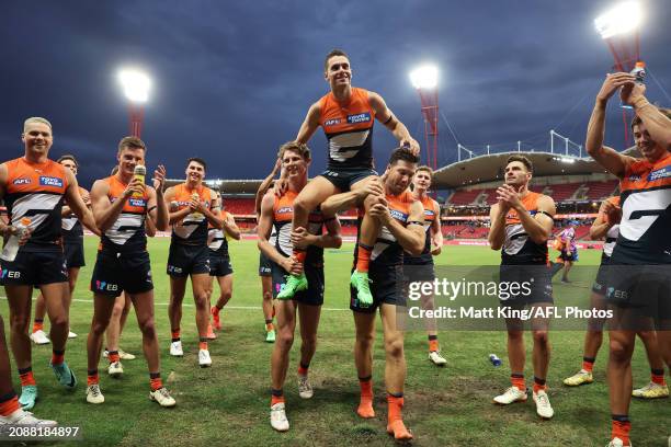 Josh Kelly of the Giants is chaired off the field by team mates during the round one AFL match between Greater Western Sydney Giants and North...