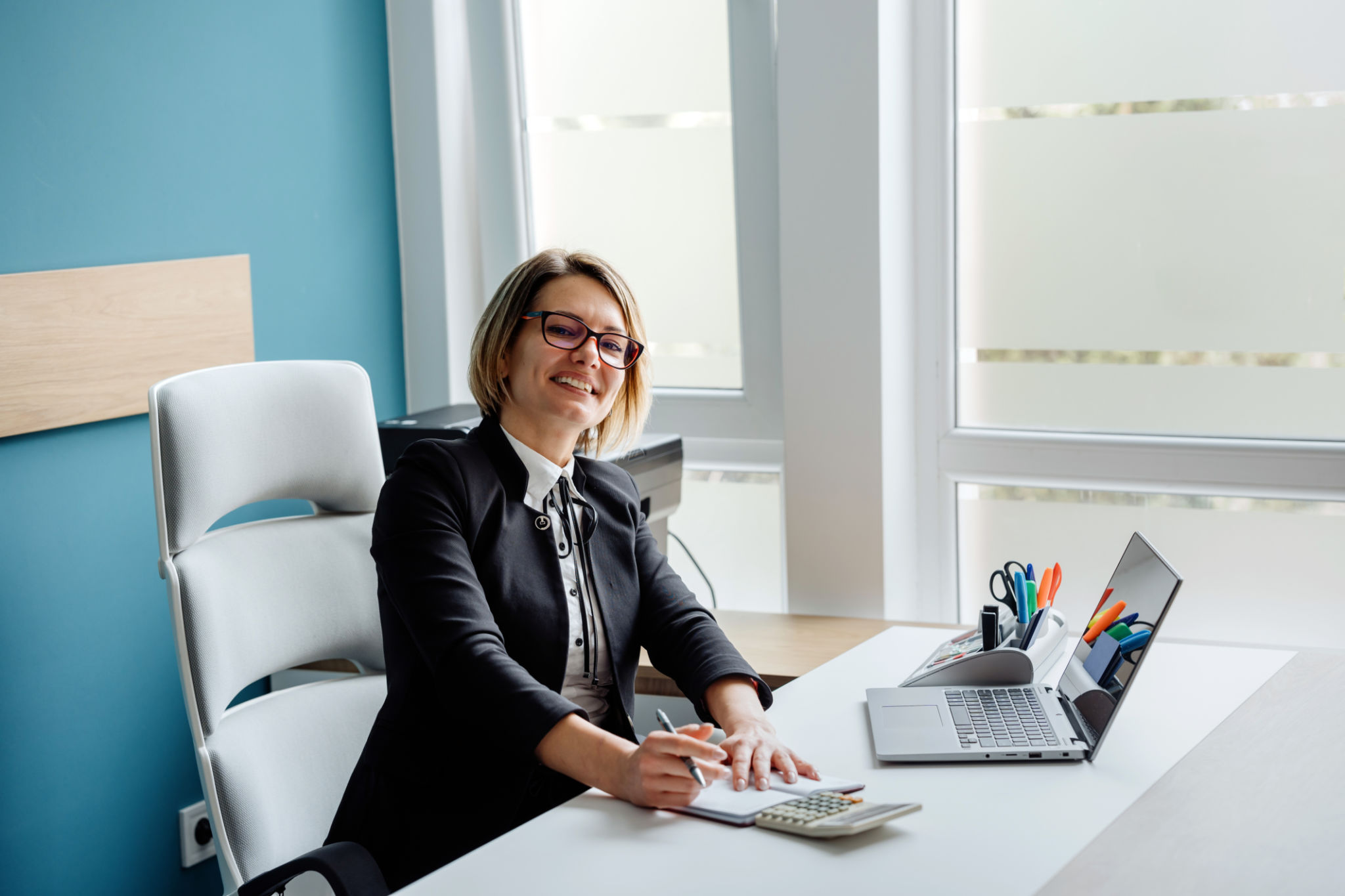 Portrait of a happy female accountant/businesswoman making financial calculations in her office Portrait of a happy female accountant/businesswoman making financial calculations in her office