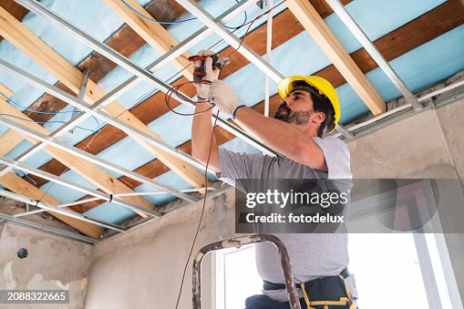 Construction Worker Installing Ceiling Frame at Site Construction Worker Installing Ceiling Frame at Site