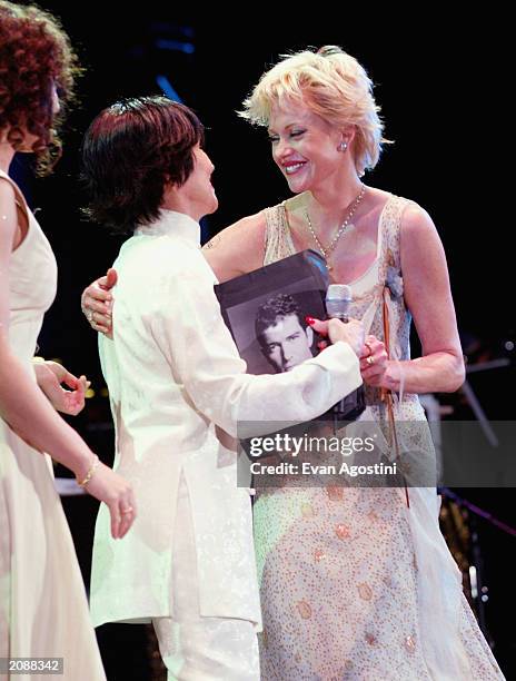 Actress Melanie Griffith hands Chita Rivera a photo of her husband Antonio Banderas during the finale at AOL Time Warner Presents 'Broadway Under The...