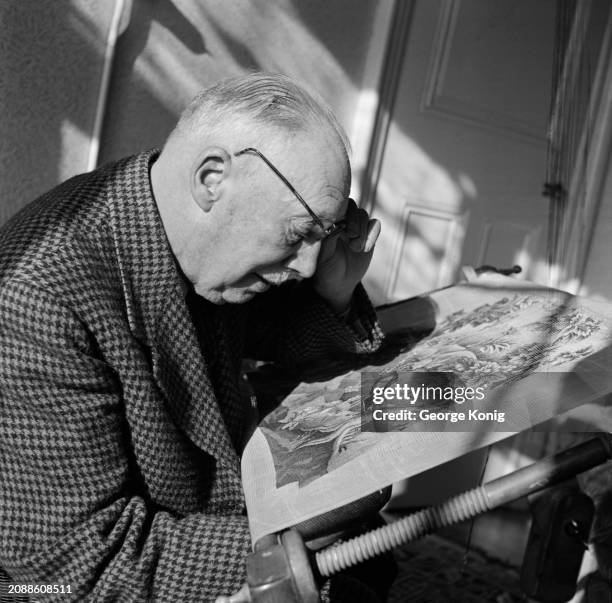 Retired British Army officer Major Martin Crawley-Boevey lifts his glasses to get a closer look at his reproduction of a Queen Anne period chair...