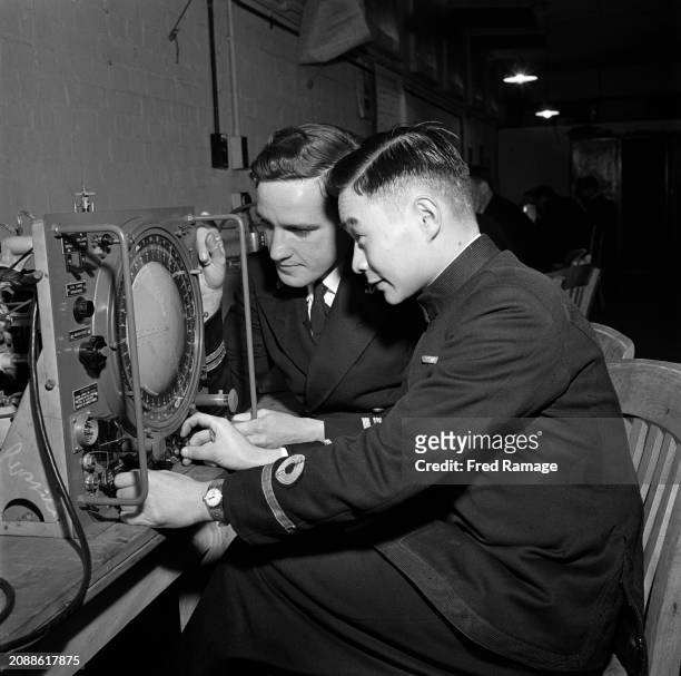 Dutch naval officer Lieutenant H Kornman and Chinese naval officer Sub-Lieutenat Ho Lien during a radar demonstration at HMS Collingwood, Western...