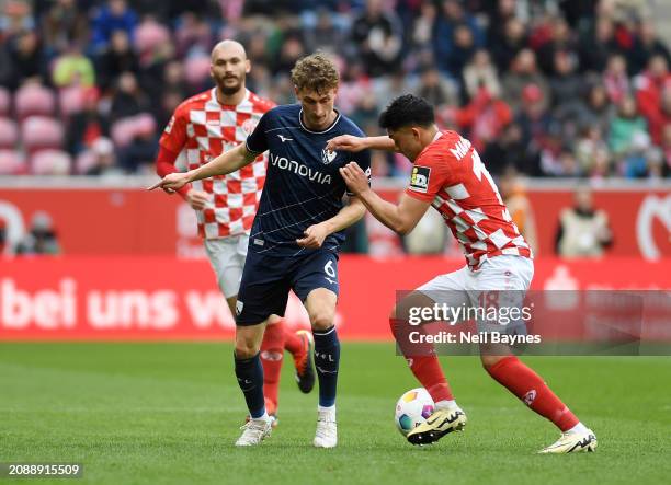 Patrick Osterhage of VfL Bochum battles for possession with Nadiem Amiri of 1.FSV Mainz 05 during the Bundesliga match between 1. FSV Mainz 05 and...