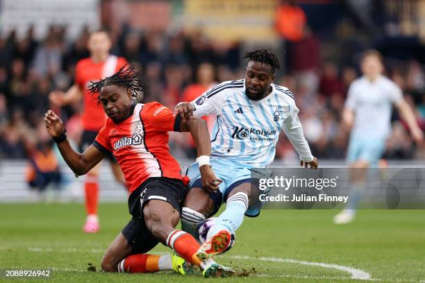 Divock Origi of Nottingham Forest is challenged by Pelly Ruddock Mpanzu of Luton Town during the Premier League match between Luton Town and...