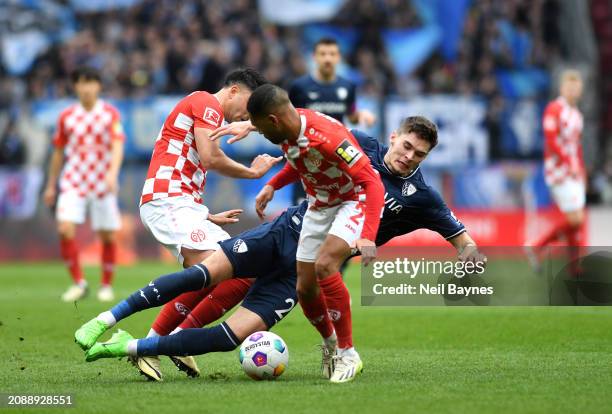 Moritz Broschinski of VfL Bochum clashes with Nadiem Amiri and Phillipp Mwene of 1.FSV Mainz 05 during the Bundesliga match between 1. FSV Mainz 05...