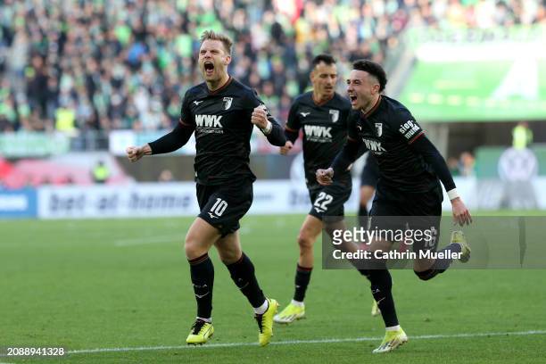 Arne Maier of FC Augsburg celebrates scoring his team's first goal with teammate Ruben Vargas during the Bundesliga match between VfL Wolfsburg and...