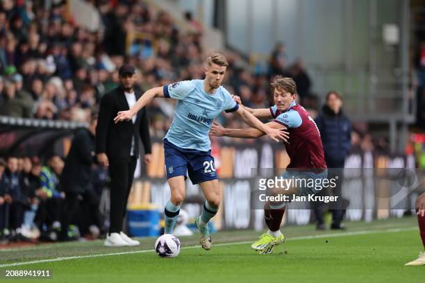 Kristoffer Ajer of Brentford is challenged by Sander Berge of Burnley during the Premier League match between Burnley FC and Brentford FC at Turf...