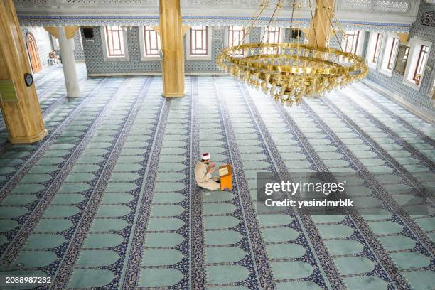 giovane imam maschio che legge il corano nella moschea durante il ramadan. - venerdì foto e immagini stock