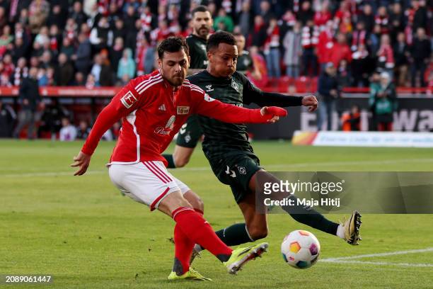 Kevin Volland of 1.FC Union Berlin shoots under pressure from Felix Agu of SV Werder Bremen during the Bundesliga match between 1. FC Union Berlin...