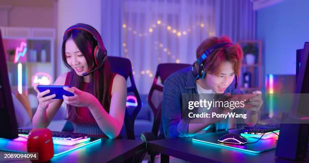 asiatique couple smartphone cyber sport - jeu mobile photos et images de collection