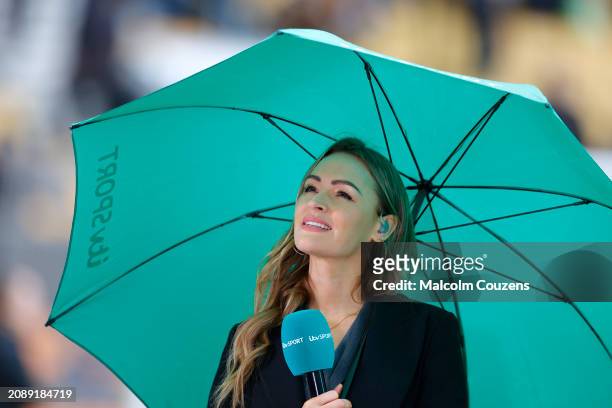 Sport presenter Laura Woods looks on from beneath an umbrella during the Emirates FA Cup Quarter Final between Wolverhampton Wanderers and Coventry...