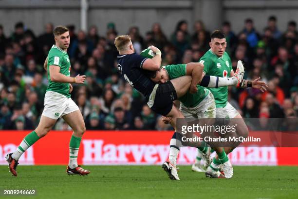 Kyle Steyn of Scotland is tackled by James Lowe of Ireland during the Guinness Six Nations 2024 match between Ireland and Scotland at Aviva Stadium...