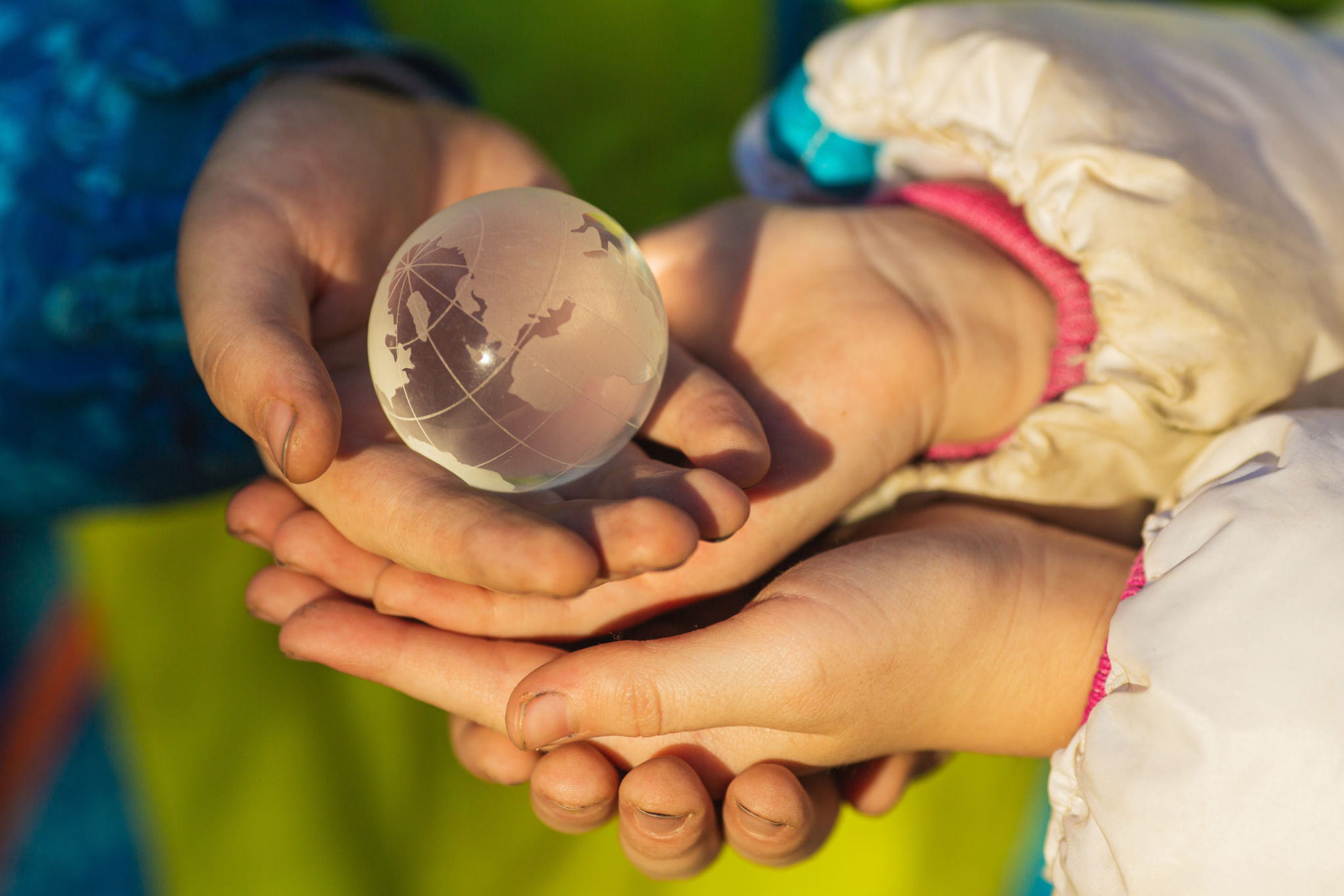 Small glass planet in children's hands. Peace concept Small glass planet in children's hands. Peace concept