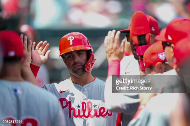 Whit Merrifield of the Philadelphia Phillies celebrates scoring against the Miami Marlins during the first inning of a spring training game at Roger...