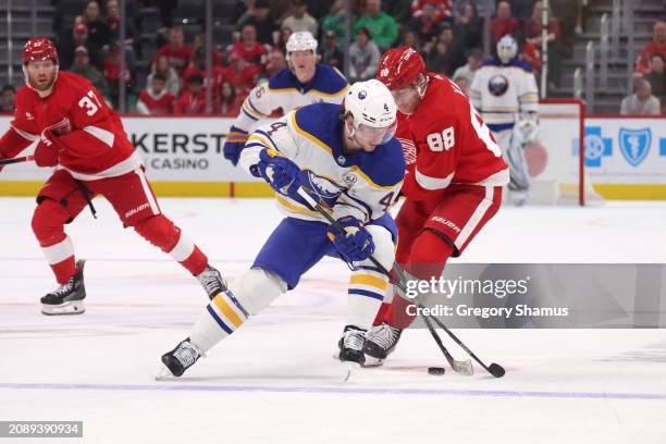 Bowen Byram of the Buffalo Sabres tries to control the puck next to Patrick Kane of the Detroit Red Wings during the first period at Little Caesars...