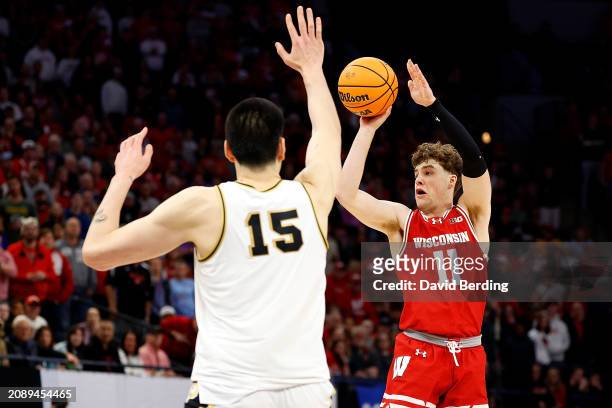 Max Klesmit of the Wisconsin Badgers passes the ball against Zach Edey of the Purdue Boilermakers during overtime at Target Center in the Semifinals...