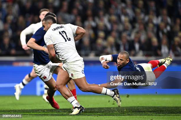 Ollie Lawrence of England makes a break past Gael Fickou of France to score his team's first try during the Guinness Six Nations 2024 match between...