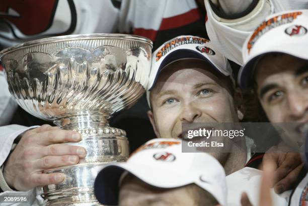 Martin Brodeur of the New Jersey Devils poses with his team and the Stanley Cup after defeating the Mighty Ducks of Anaheim in game seven of the 2003...