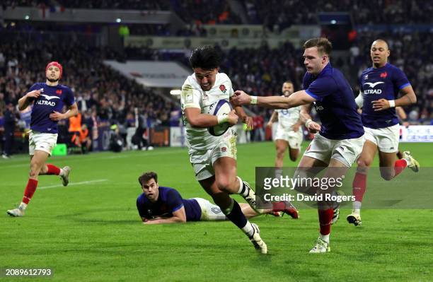 Marcus Smith of England makes a break past Leo Barre of France to score the team's third try during the Guinness Six Nations 2024 match between...