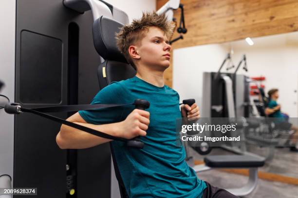 adolescente haciendo ejercicio en un gimnasio - entrenamiento de fuerza fotografías e imágenes de stock